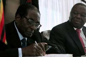 Robert Mugabe signe la nouvelle Constitution au côté de son Premier ministre Morgan Tsvangirai, à © Jekesai Njikizana/AFP