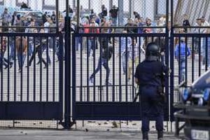Des Marocains jettent des pierres contre l’enclave espagnole de Melilla, en octobre 2012. © AFP