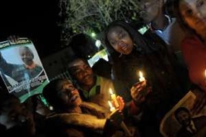 Des Sud-Africains en prière le 27 juin 2013 devant la clinique où est hospitalisé Nelson Mandela. © AFP
