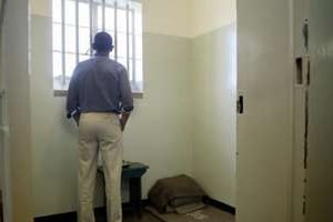 Barack Obama dans la cellule où Nelson Mandela avait été emprisonné, à Robben Island. © AFP