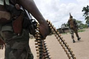 Des hommes armés lors de l’attaque d’un poste de l’armée ivoirienne à Agbaou, fin 2012. © AFP
