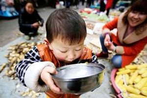 Un enfant consomme du lait, à Shanghai, en mars. © Eugene Hoshiko/AP/Sipa