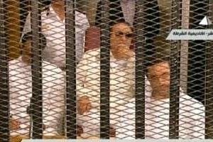 Capture d’écran de la TV égyptienne de Hosni Moubarak entre ses fils Gamal et Alaa l. © AFP