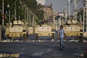 Un homme passe devant des blindés de l’armée égyptienne, le 13 juillet 2013 au Caire. © AFP