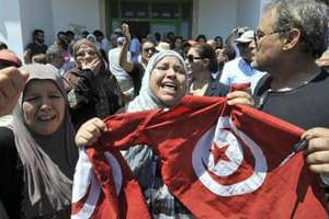 Des Tunisiens brandissent un drapeau après le meurtre, le 25 juillet 2013, de Mohamed Brahmi. © Féthi Belaid/AFP