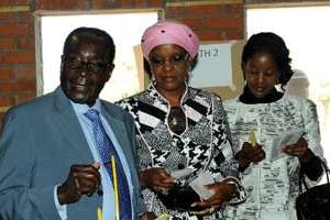 Le président Robert Mugabe vote avec sa femme et sa fille le 31 juillet 2013 à Harare. © AFP
