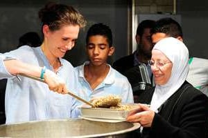 Asma al-Assad, à gauche, dans un orphelinat de Damas, le 4 août. © AFP