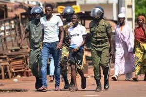 Des gendarmes guinéens arrêtent des personnes à Conakry après une manifestation, le 27 février. © AFP