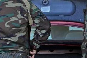 Des militaires inspectent le coffre d’un véhicule lors d’un contrôle de sécurité à Tripoli. © AFP