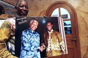 Pathé’O montre une photo de lui et Mandela, dans son atelier de Treichville, en Côte d’Ivoire. © Hervé Sévi/AFP