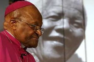 Desmond Tutu devant un portrait de Mandela le 30 juillet 2013 au Cape. © AFP