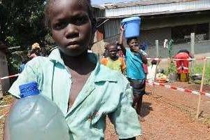 Une jeune fille porte une bouteille d’eau dans un centre catholique de Bangui, le 14 décembre 2013. © AFP