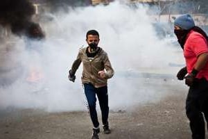 Des partisans du président égyptien déchu Mohamed Morsi fuient les gaz lacrymogènes. © AFP
