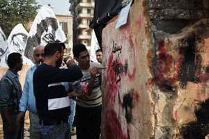 Des Egyptiens peignent un graffiti sur un monument dédié aux victimes des soulèvements © AFP