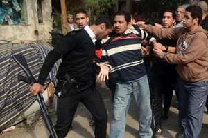 Un policier arrête un partisan des Frères musulmans le 25 janvier 2014 au Caire. © AFP