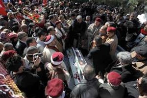 Des personnes se recueillent sur la tombe de l’opposant Chokri Belaïd. © AFP