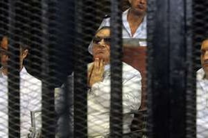 Hosni Moubarak et ses deux fils Gamal (g) et Alaa (d) au tribunal en août 2013. © AFP