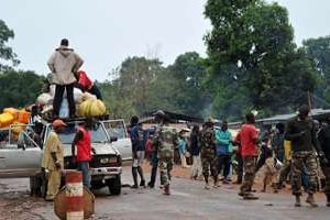 Des membres des milices anti-Balaka fouillent un véhicule à un point de contrôle au sud de Bangui © AFP