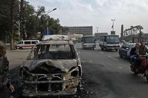 La carcasse calcinée d’un véhicule incendié lors d’incidents le 9 mars 2014 au Caire. © AFP