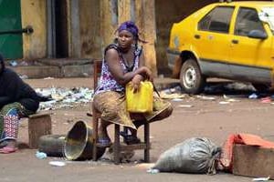 Guinéenne assise avec un bidon d’eau vide dans le quartier Bambeto à Conakry. © AFP