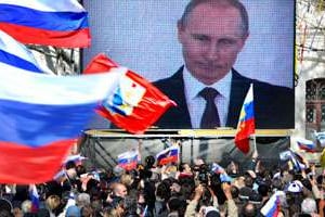 Vladimir Poutine l’annonce sur grand écran à Sébastopol, le 18 mars : la Crimée est russe. © VIKTOR DRACHEV/afp