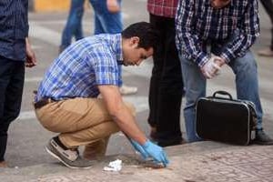 Des enquêteurs sur le lieu de l’explosion d’une bombe le 15 avril 2014 au Caire. © AFP