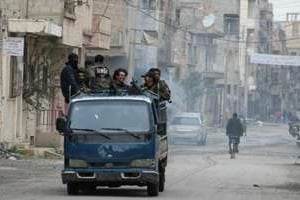 Des combattants rebelles patrouillent dans la ville de Deir Ezzor, le 10 mars 2014. © AFP