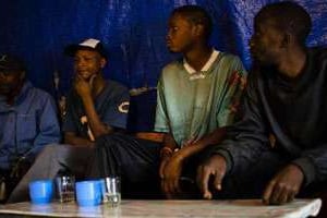 Des hommes consomment de l’alcool dans le bidonville de Mathare le 27 juin 2013 à Nairobi. © AFP