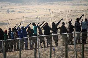 Des immigrants d’origine subsaharienne à la frontière entre Maroc et Melilla, le 1er mai 2014. © AFP
