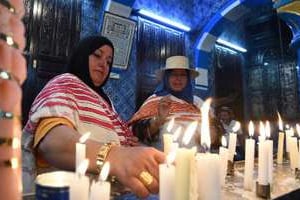 Des pèlerines juives allument des cierges dans la synagogue de la Ghriba, le 18 mai 2014. © AFP