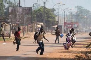 Des habitants de Bangui courent se mettre à l’abri alors que des tirs retentissent. © AFP