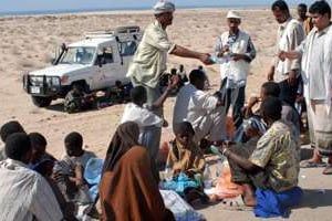 Des membres d’une ONG yéménite viennent en aide à des migrants, 230 km à l’est du port d’Aden. © Khaled Fazaa/AFP