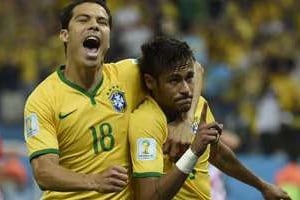L’attaquant brésilien Neymar (d.) fête son but avec le milieu de terrain Hernanes, le 12 juin. © AFP