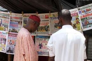 Des Maliens lisent les quotidiens titrant sur la défaite de Kidal, le 23 mai 2014. © AFP