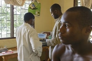 Le jeune lauréat Arthur Zang (centre) et un médecin testent le CardioPad sur un patient à l’hôpital Mbankomo, à 25 kilomètres de Yaoundé. © Rolex