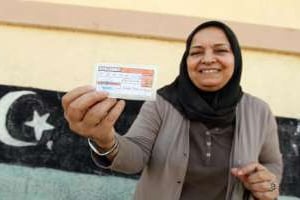 Une Libyenne montre sa carte d’électeur après avoir voté pour élire un nouveau Parlement. © AFP