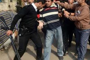 Un policier arrête un partisan des Frères musulmans, le 25 janvier 2014 au Caire. © AFP