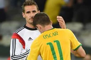 L’attaquant allemand Miroslav Klose (g) tente de consoler le Brésilien Oscar, le 8 juillet 2014. © L’attaquant allemand Miroslav Klose (g) tente de consoler le Brésilien Oscar, le 8 juillet 2014 a