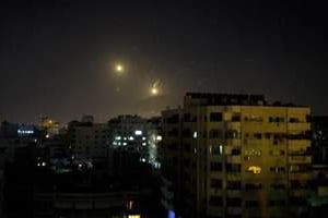 L’artillerie israélienne illumine le ciel de la ville de Gaza après un raid aérien le 8 juillet. © AFP