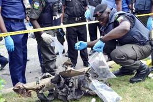 Des experts et des forces de l’ordre nigerians récupérent des débris après une explosion à Abuj © AFP