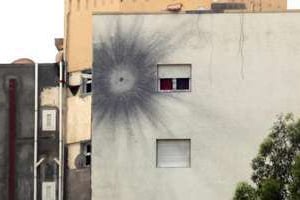L’impact d’une roquette sur le mur d’un immeuble le 19 mai 2014 près de l’aéroport de Tripoli. © AFP