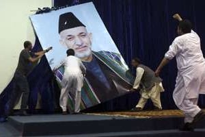 Des partisans d’Abdullah Abdullah décrochent un portrait de Hamid Karzaï, le président sortant. © Omar Sobhani/Reuters