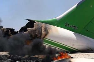 Un avion en flammes le 16 juillet 2014 sur le tarmac de l’aéroport international de Tripoli. © AFP
