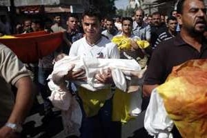 Un Palestinien pleure en portant le corps d’un bébé tué lors d’une frappe israélienne, à Gaza. © AFP