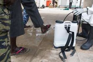 Désinfection des chaussures de visiteurs dans un hôpital pour éviter la propagation du choléra. © AFP