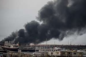 Un bâtiment en feu dans le port de Gaza après des frappes israéliennes. © AFP
