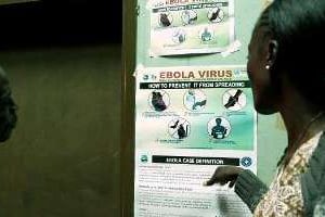Des habitants de Monrovia au Liberia lisent une affiche d’information sur le virus Ebola. © AFP
