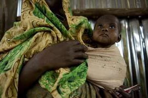 Un enfant et sa mère attendent de la distribution de nourriture à Dollow. © AFP