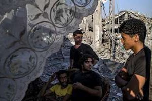 Des Palestiniens devant une maison détruite à Shejaiya, le 6 août 2014 à Gaza. © AFP