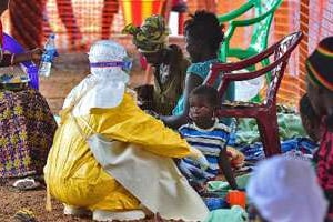 Un médecin de MSF examine un enfant contaminé par le virus Ebola. © AFP